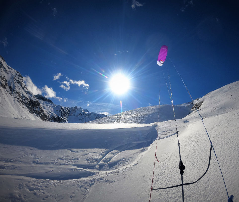 Der neue Ozonekite SubzeroV2 ib der Farbe purple zieht den Kiter mit den Ski über den Schnee mit Hilfe des Windes.