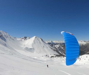 Der subzeroV2 ist ein Kite in der Farbe blau vor weißem Schnee. Er zieht einen Snowkiter auf Ski über den Schnee.